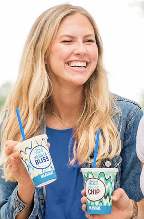 Woman laughs holding 2 freal milkshakes next to campaign results